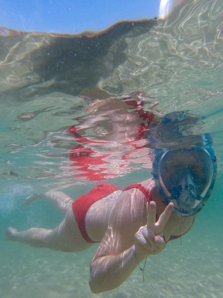 Sea swimmer showing the peace sign under water