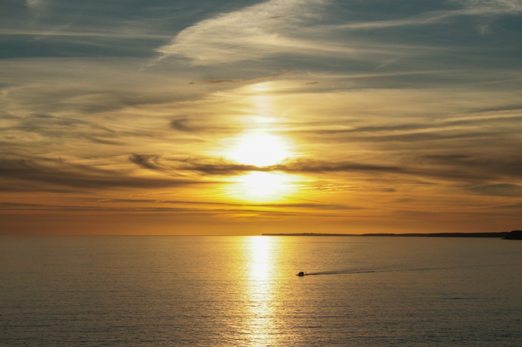 Seascape sunset with passing boat